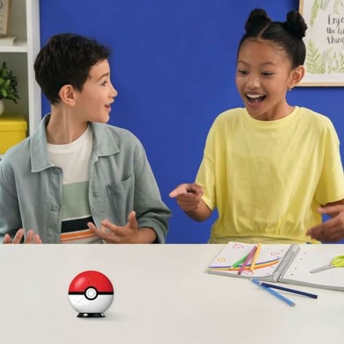 Twee kinderen zijn enthousiast over een Pokébal op tafel.