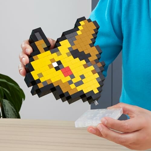 Persoon houdt pixelachtig bouwblokfiguur vast